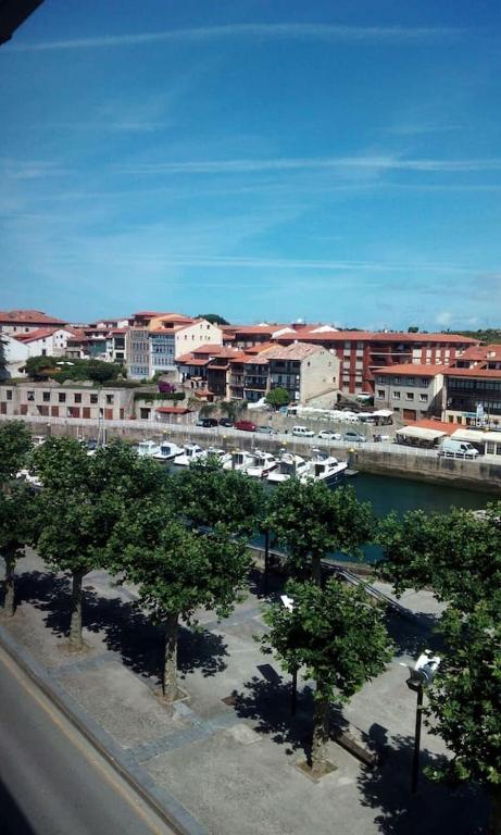a view of a city with a marina and buildings at San Anton, Ventana al mar in Llanes