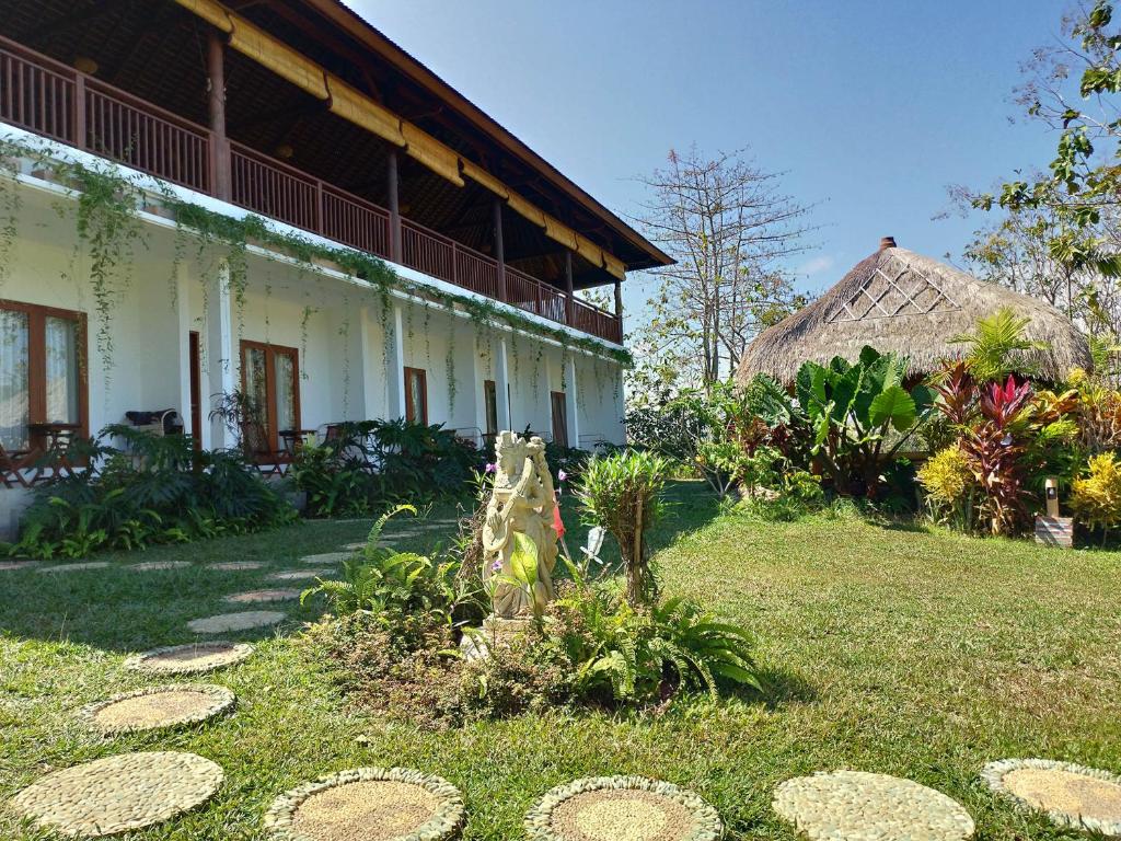 a building with a grass yard in front of it at Lala Homestay Bingin in Uluwatu