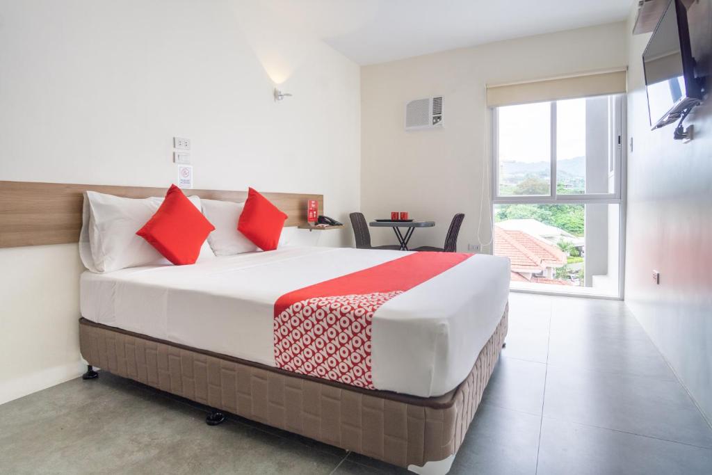 a bedroom with a large bed with red pillows at 18 Suites Cebu in Cebu City