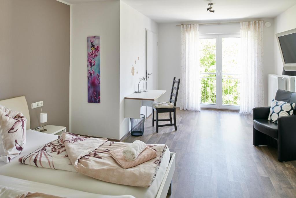 a bedroom with a bed and a chair and a desk at Schwanenhof Hotel und Restaurant in Erkelenz