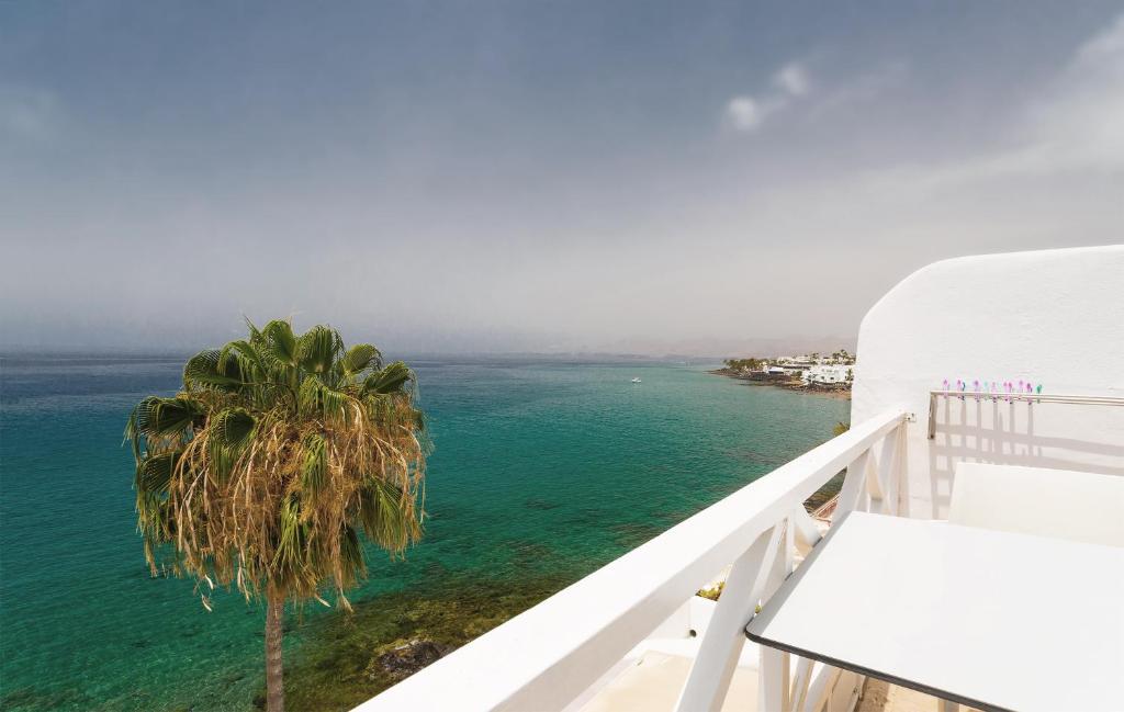 un balcone con vista sull'oceano e palme di Cabrera Suit a Puerto del Carmen