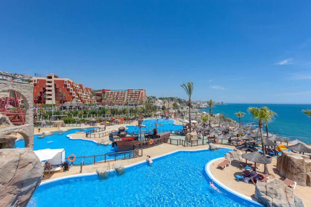 um resort com uma grande piscina junto ao oceano em Holiday World Resort em Benalmádena