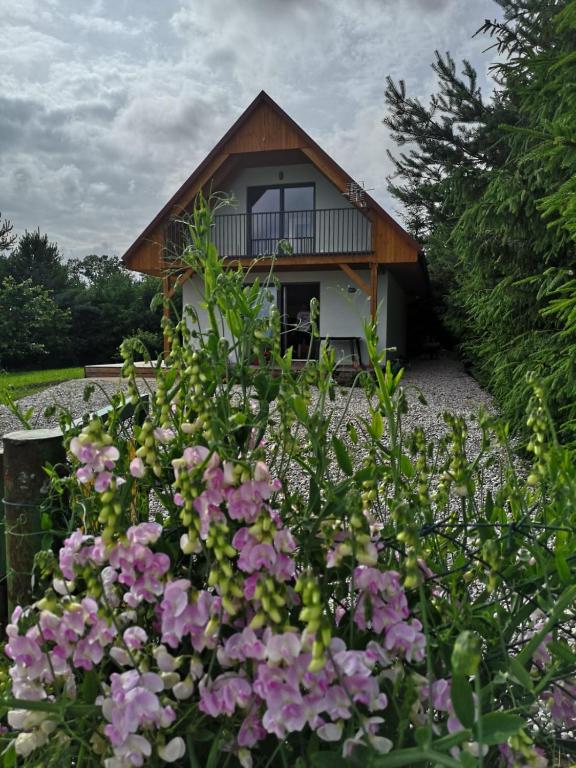 a house with a bunch of flowers in front of it at Grzybowo Dom wakacyjny in Grzybowo