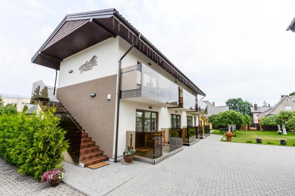 a house with a large window and a staircase at Vila Tante in Šventoji