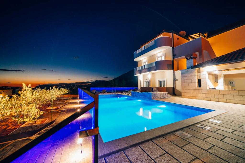 una villa con piscina di notte di Sun Haven Luxury Apartments a Cavtat