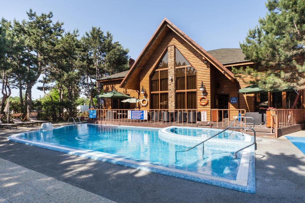 a large swimming pool in front of a house at Kompleks Otdykha Elki-Palki in Odesa