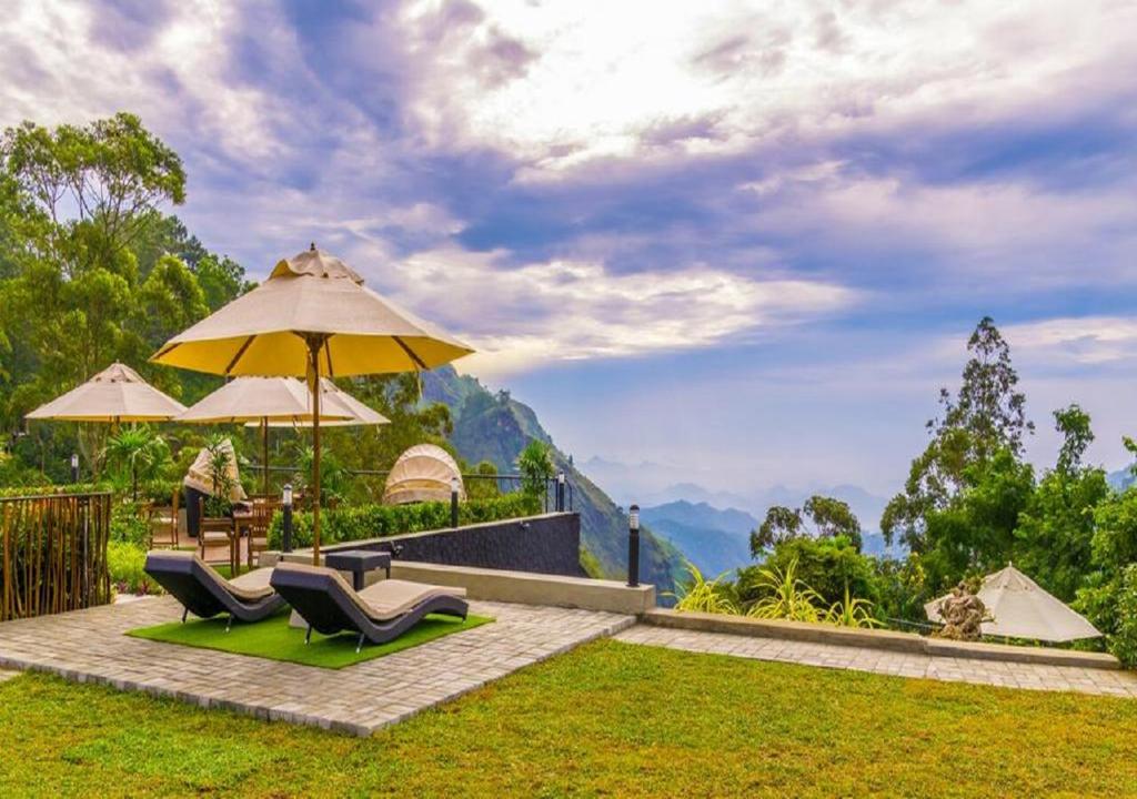 a patio with two chairs and an umbrella at EKHO Ella in Ella