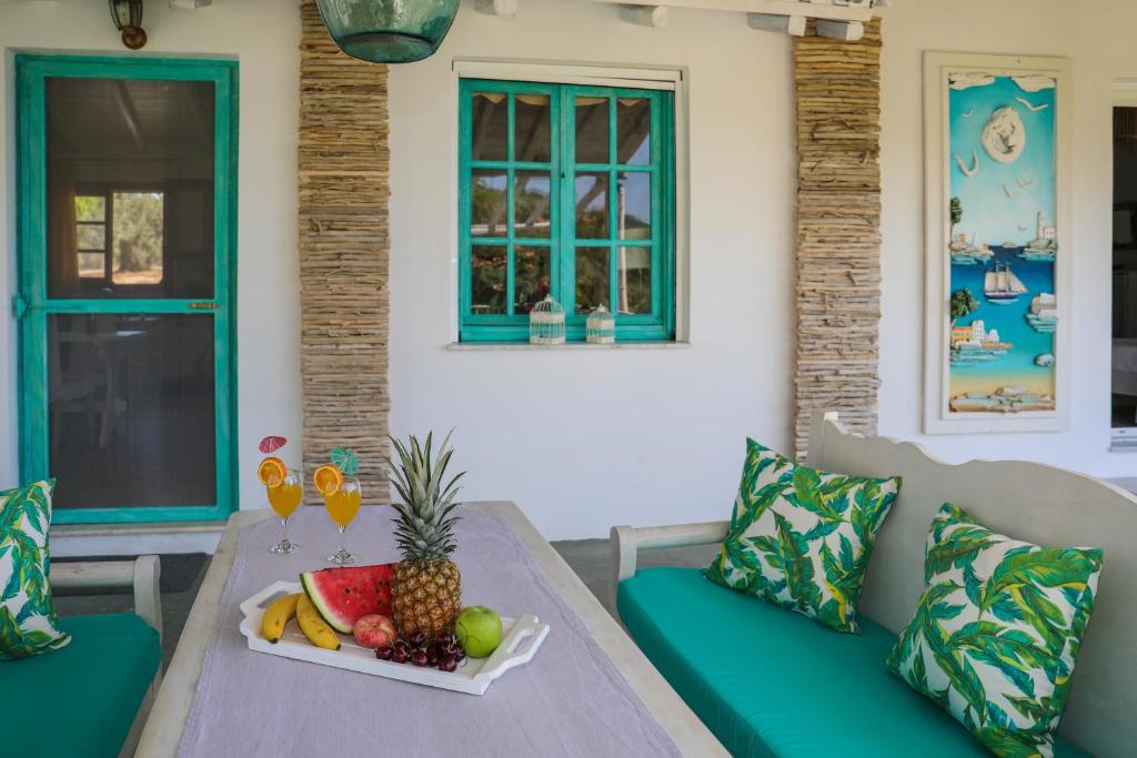 a table with a tray of fruit and two glasses of wine at Georgia Villas in Skiathos