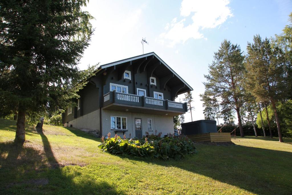 una casa con balcone e fiori in erba di Martinmäki a Virrat