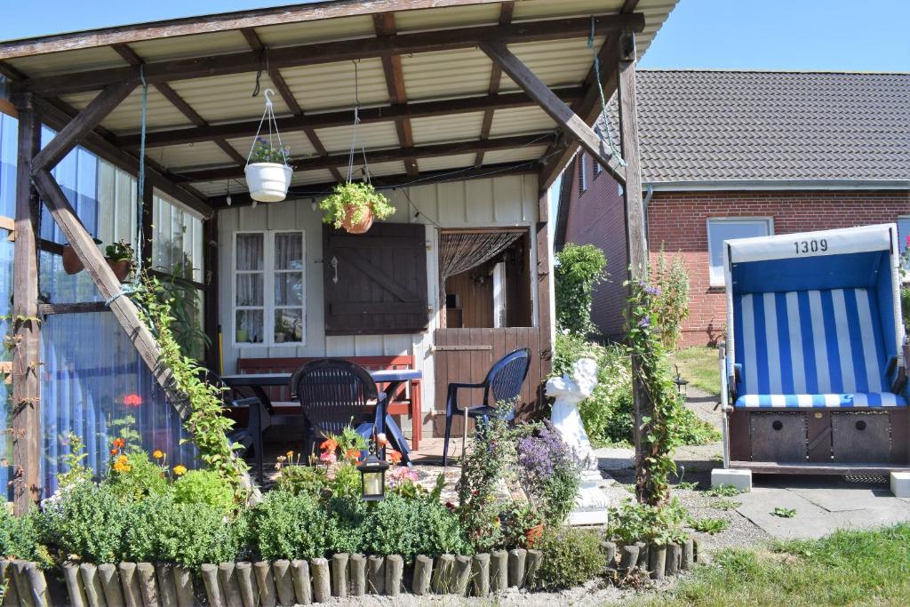 eine überdachte Terrasse mit einem Tisch und Stühlen auf einem Haus in der Unterkunft Haus Henriette in Emmelsbüll-Horsbüll