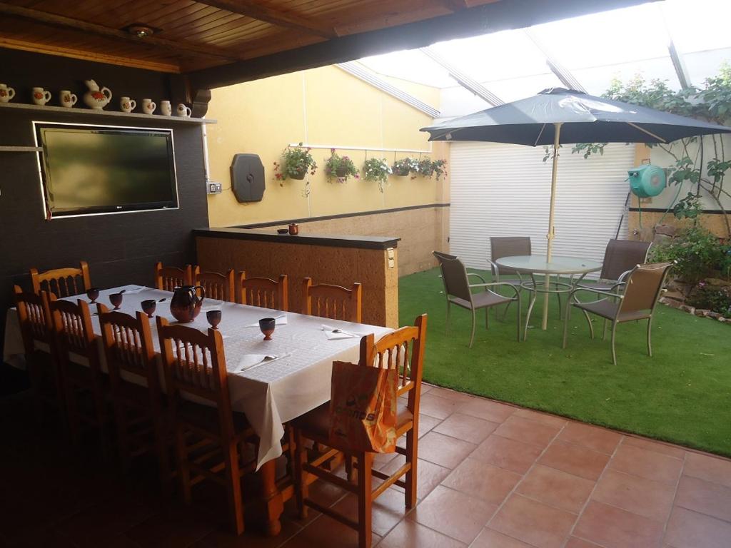 una mesa, sillas y una sombrilla en el patio en CASA RURAL LA SUITE DE ALMAGRO, en Almagro