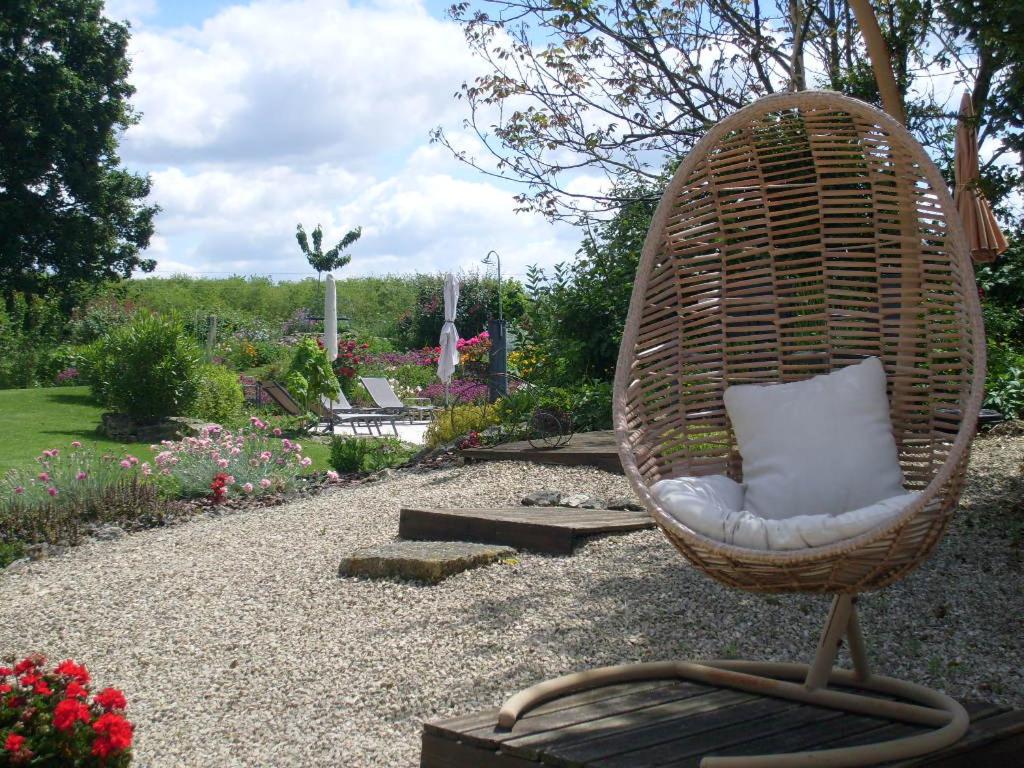 a wicker chair sitting in the middle of a garden at La Grange de Gournay in  Gournay-Loizé