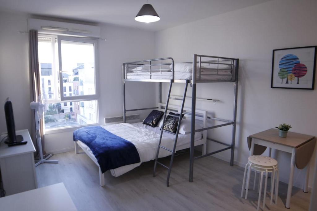 sypialnia z 2 łóżkami piętrowymi i biurkiem w obiekcie NEW- Relaxing studio - 5 min from Disneyland Paris w mieście Montévrain
