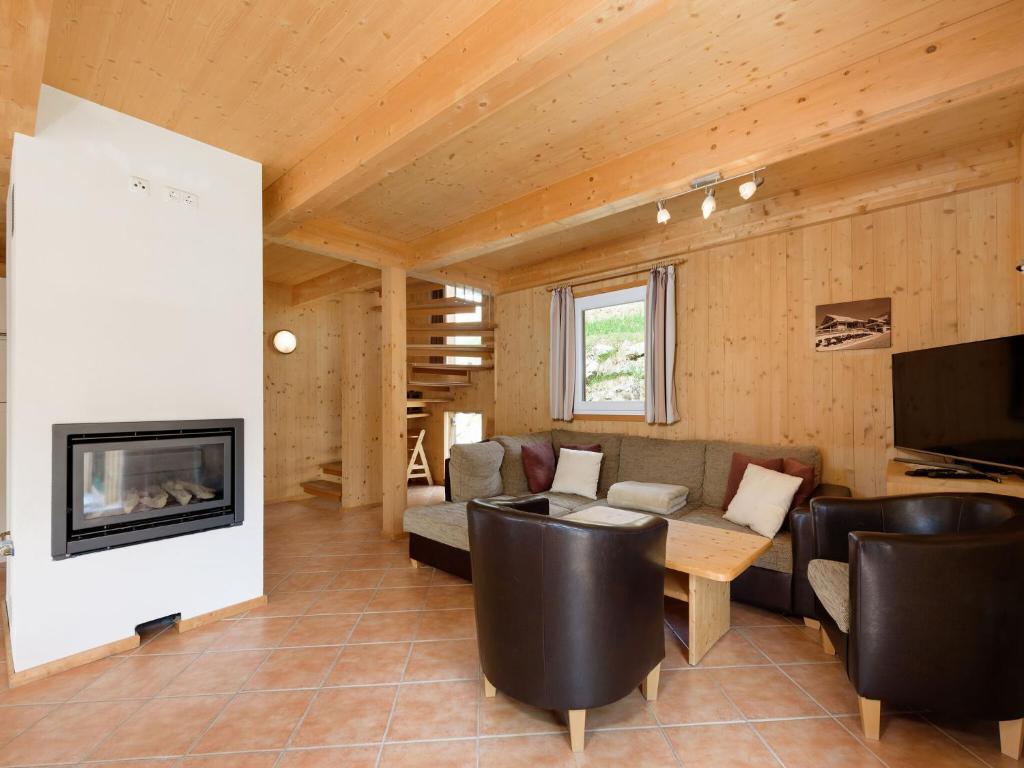 a living room with a couch and a fireplace at Wooden chalet in Hohentauern Styria with sauna in Hohentauern