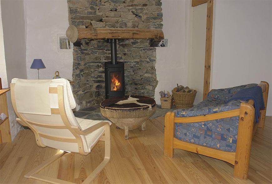 1 dormitorio con chimenea, silla y cama en leKarl, en Queyrières