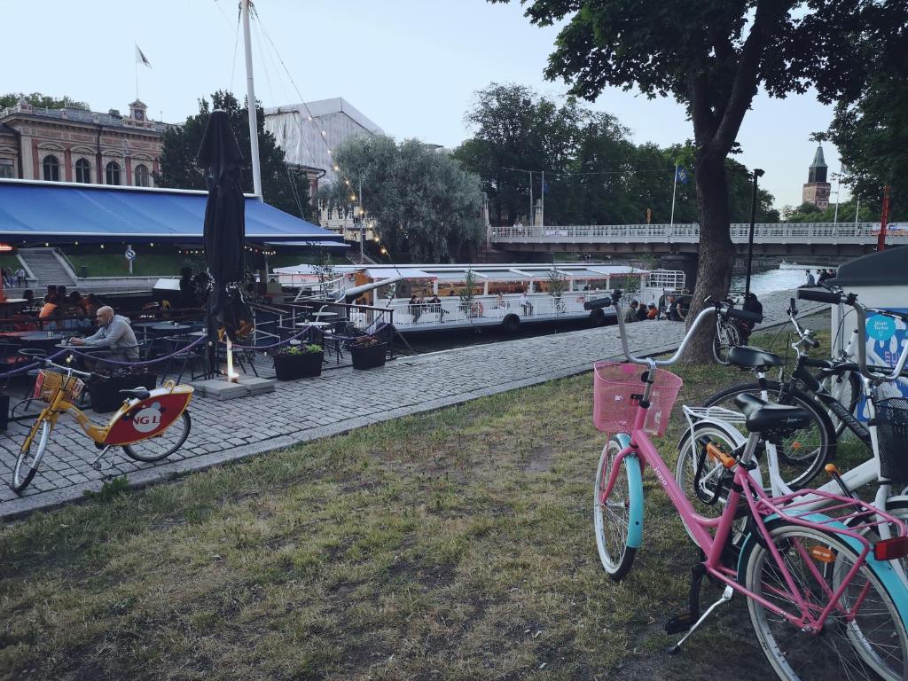 um grupo de bicicletas estacionadas ao lado de um rio com um barco em Poshtel Turku Hostel em Turku