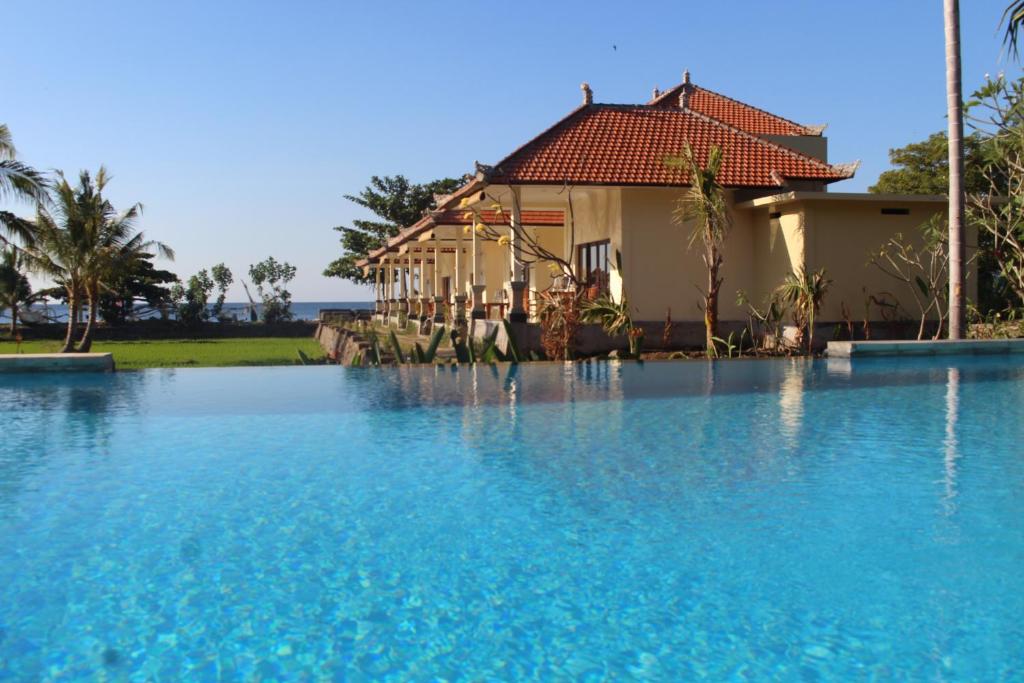 ein Haus mit einem Pool vor einem Haus in der Unterkunft Taman Padi Villa in Amed