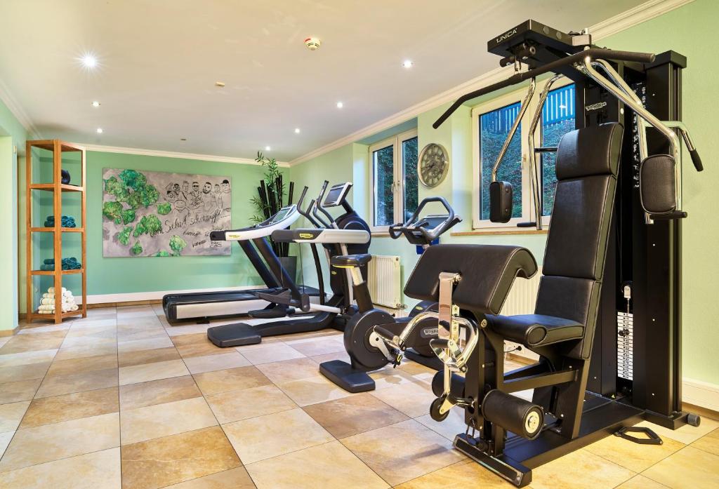 a gym with treadmills and cardio equipment in a house at Garden & SPA Hotel Das Götzfried in Regensburg