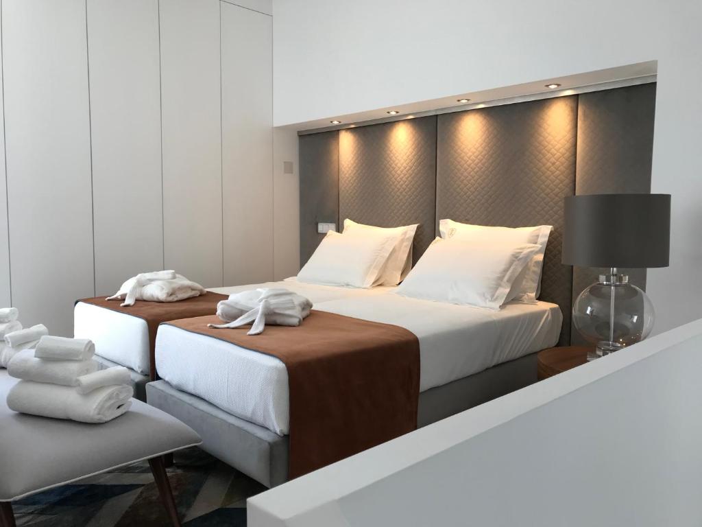 Habitación de hotel con 2 camas y toallas. en CASA DO CABIDO - Elegance in simple traits, en Évora