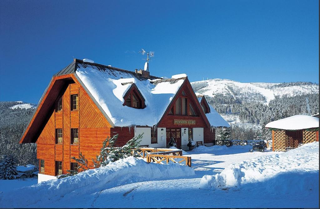 a large wooden cabin with snow on the roof at PENSION KUBU Apartment 3 samostatný byt s kuchyní in Špindlerův Mlýn