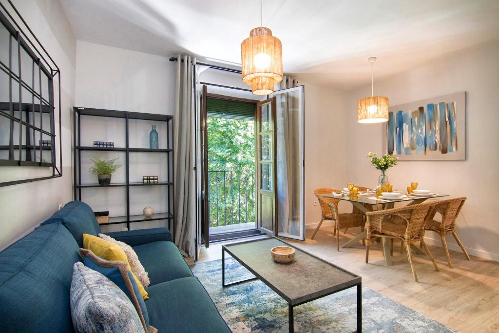 sala de estar con sofá azul y mesa en Apartamentos Los Lobos en Granada