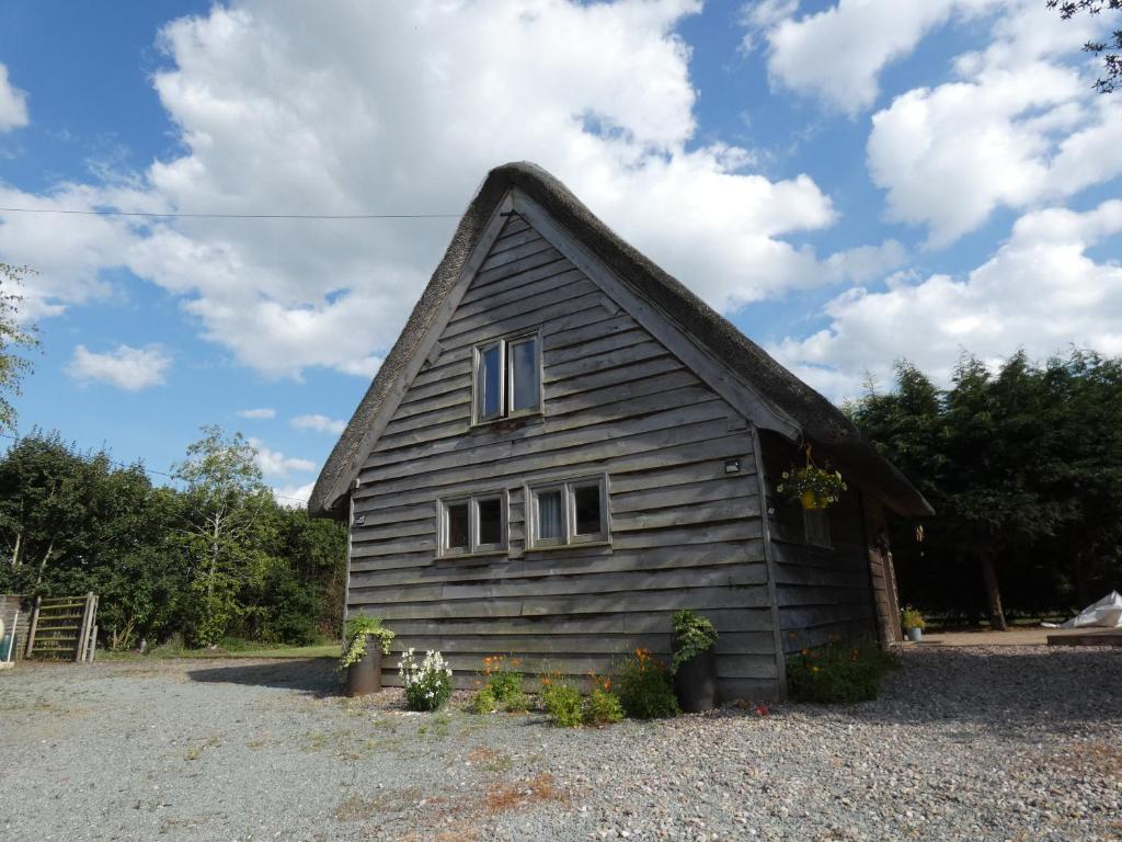 Cette petite maison est dotée d'un toit de chaume. dans l'établissement Yew Tree Barn, à Prees