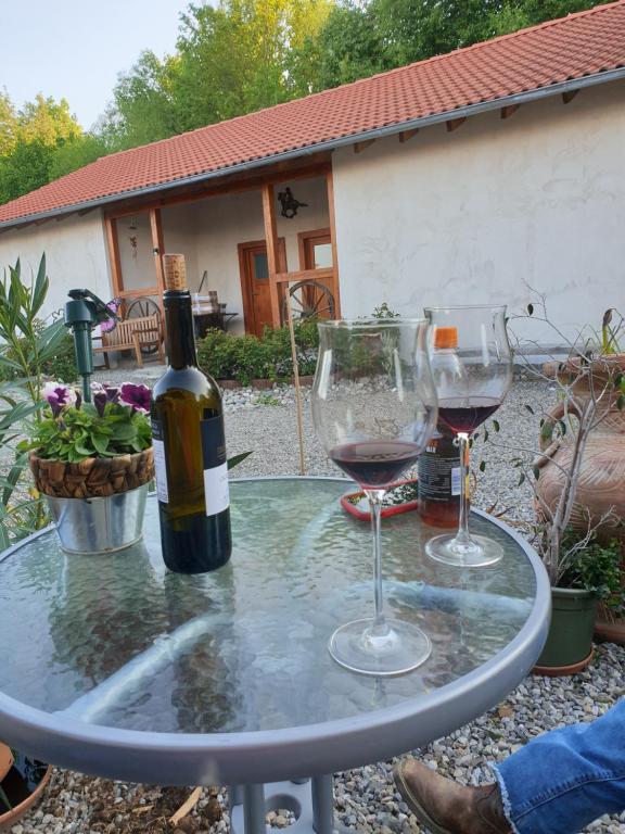 a table with two glasses and a bottle of wine at Chrom Ranch Reiterhof in Memmingen