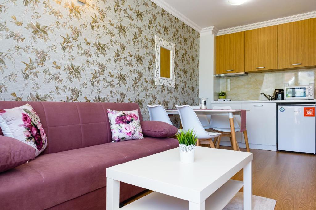 a living room with a purple couch and a white table at Sweet Homes Apartments in Sunny Beach