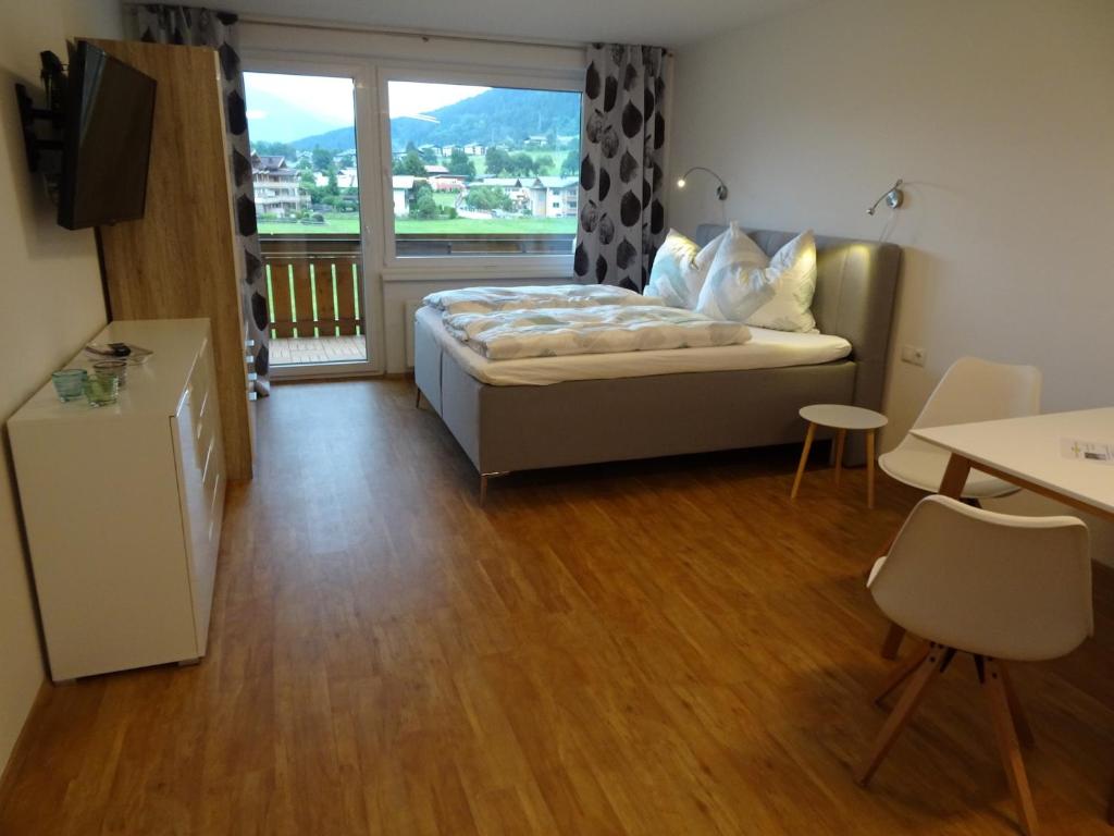 ein Schlafzimmer mit einem Bett und einem großen Fenster in der Unterkunft Ferienappartement GROCKE in Kaprun