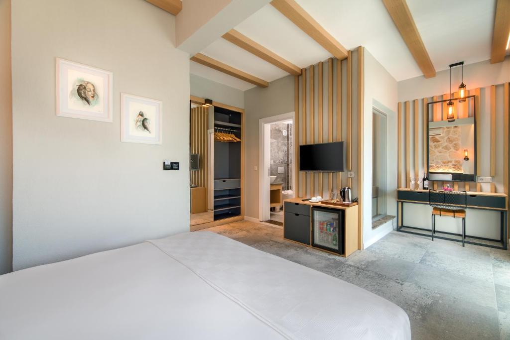 a bedroom with a large bed and a television at Isola 12 Hotel in Kas