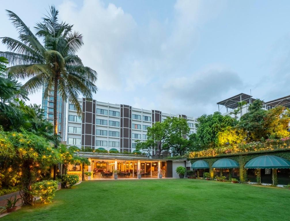 an exterior view of a hotel with a large yard at Kenilworth Hotel, Kolkata in Kolkata