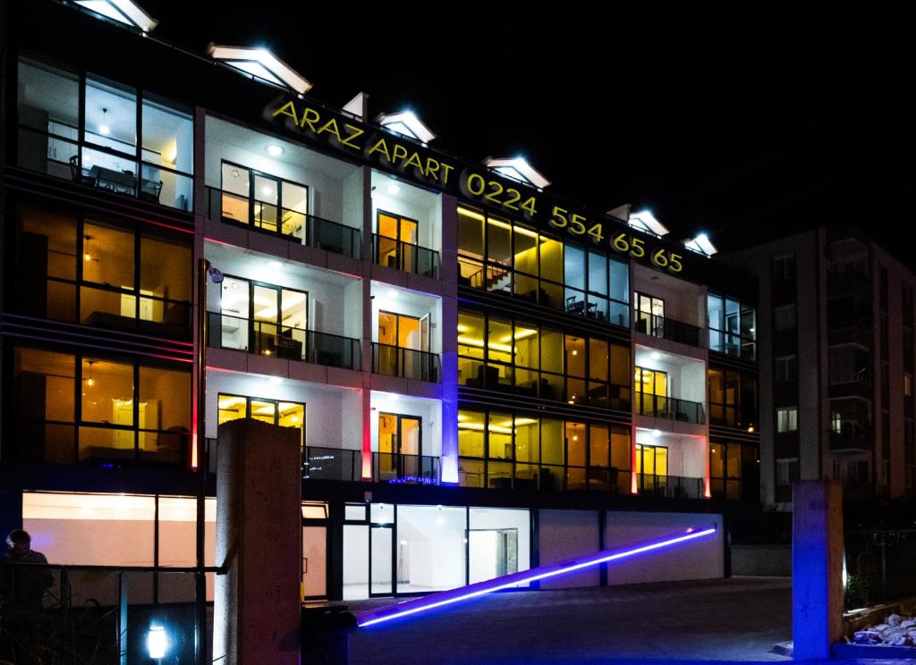 um edifício de apartamentos à noite com luzes acesas em Araz Suit Otel em Burgaz