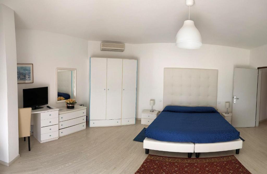 una camera con letto blu e televisore di Hotel King a Lido di Jesolo