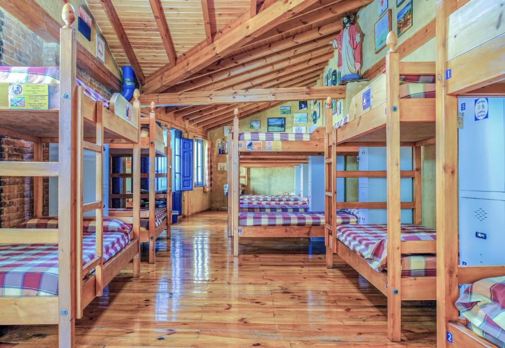 a row of bunk beds in a small room at Albergue de Peregrinos-San Miguel in Hospital de Órbigo