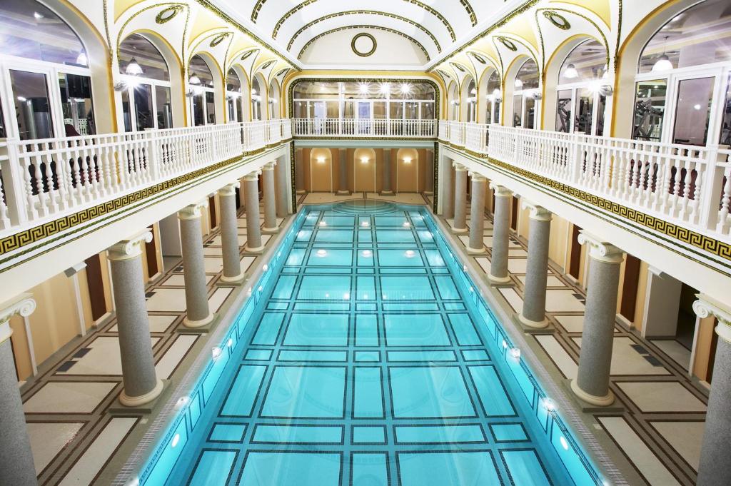 a pool in the middle of a building with columns at Londonskaya SPA Hotel in Odesa