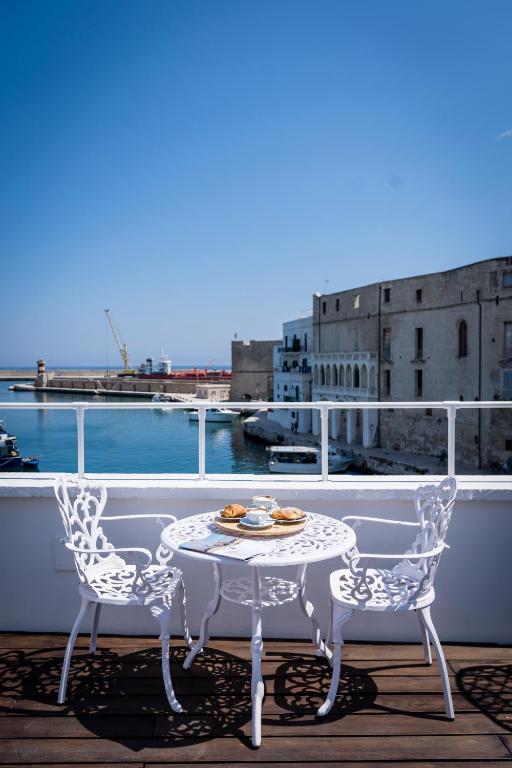 a white table and two chairs on a balcony at AL CONSOLE LUXURY SUITE in Monopoli