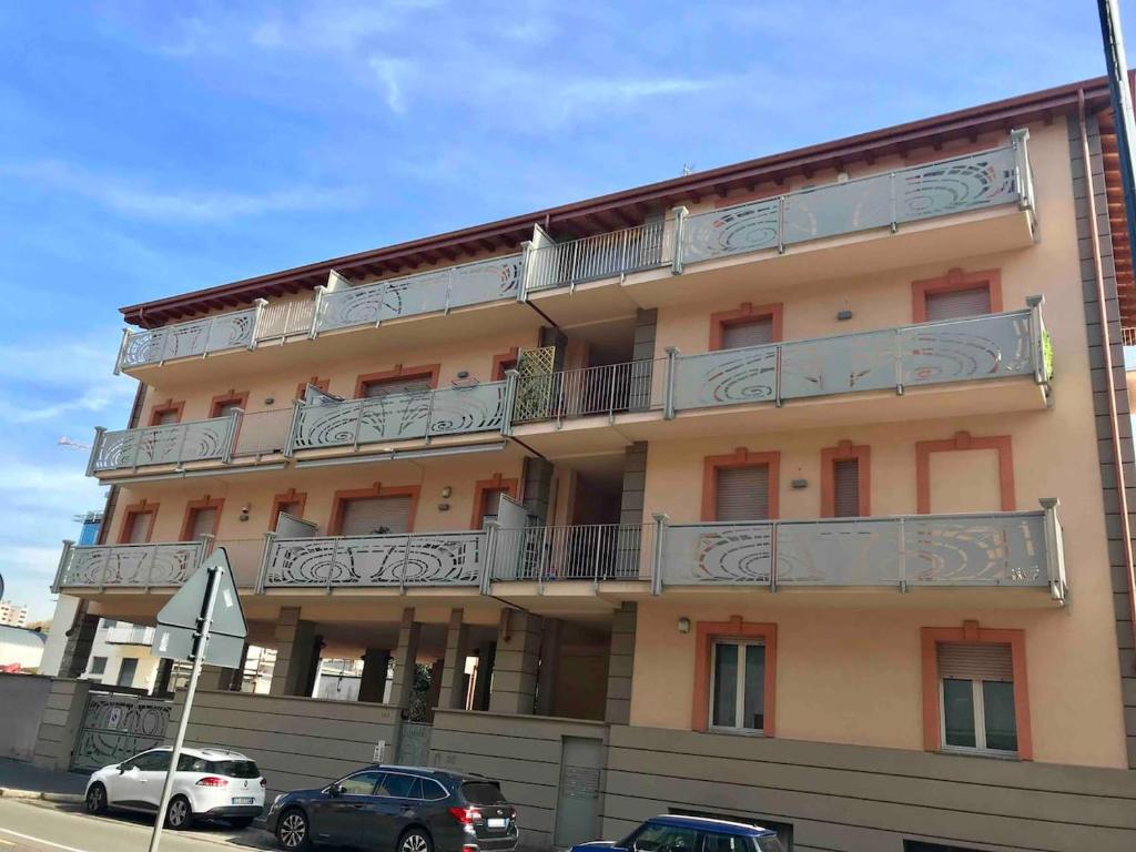 a building with balconies and cars parked in front of it at Rooftop big Terrace fiera MIlano/Portello in Milan