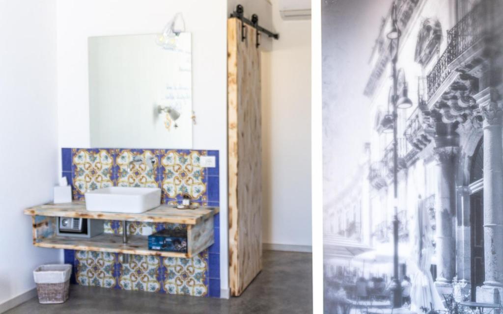 瑪爾薩梅米的住宿－Isola dei poeti，浴室设有桌子和一幅画墙