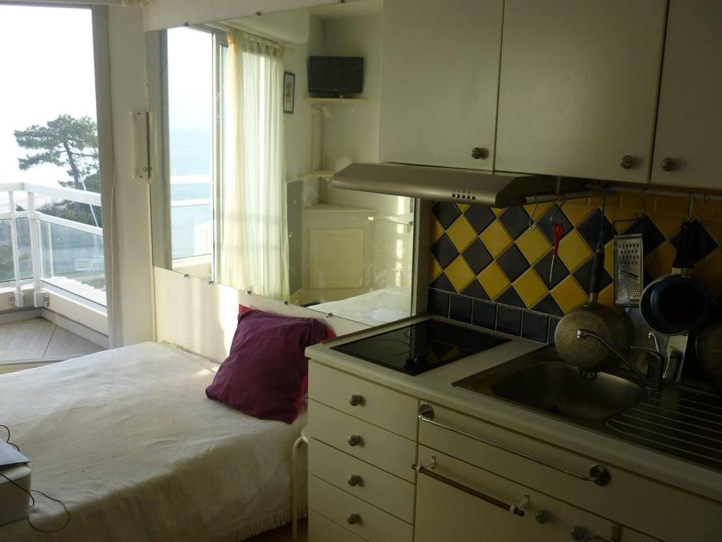 - une cuisine avec un lit, un évier et une fenêtre dans l'établissement Studio avec balcon sur plage Pereire Pleine vue mer, à Arcachon