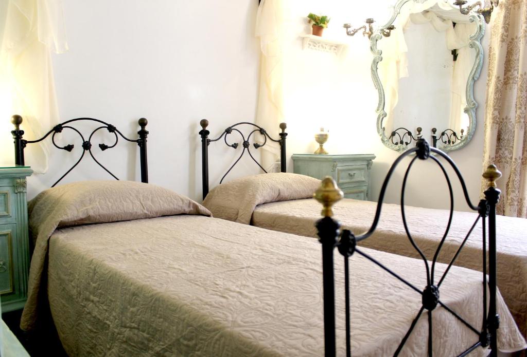 a bedroom with two beds and a mirror at Kharmen A 1565s House with Seaviews in Birgu