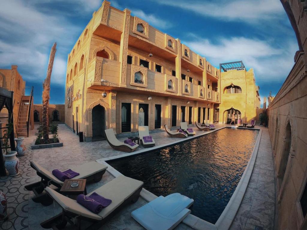 a hotel with a pool in front of a building at Casa d'Or Dahab PALAZZO in Dahab