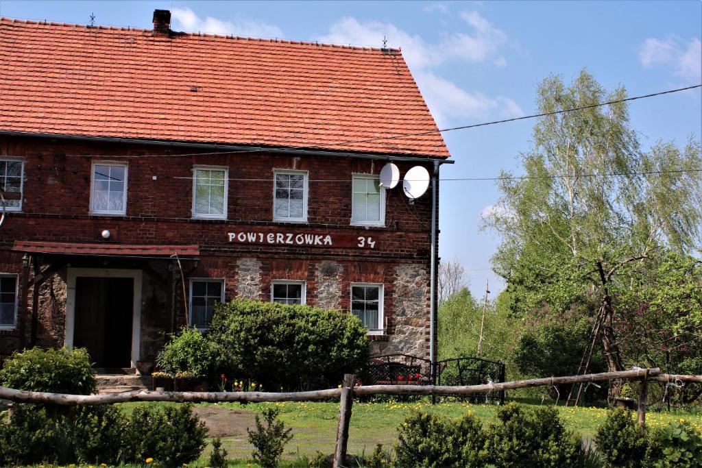 an old brick building with a red roof at Gospodarstwo Agroturystyczne Powierzówka in Leśna
