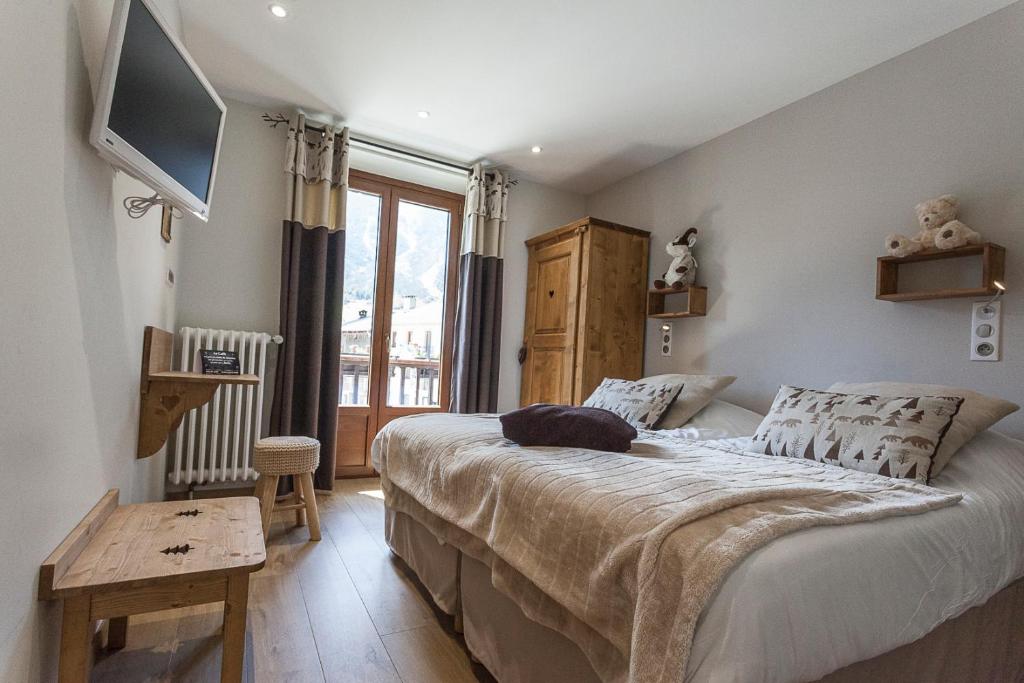 ein Schlafzimmer mit einem Bett und einem TV an der Wand in der Unterkunft Hotel la Turra in Termignon