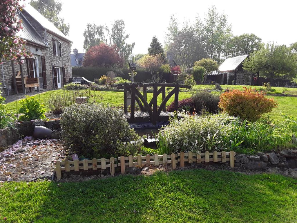 a garden with a wooden fence in front of a house at La Bannerie in Mesnil-Clinchamps