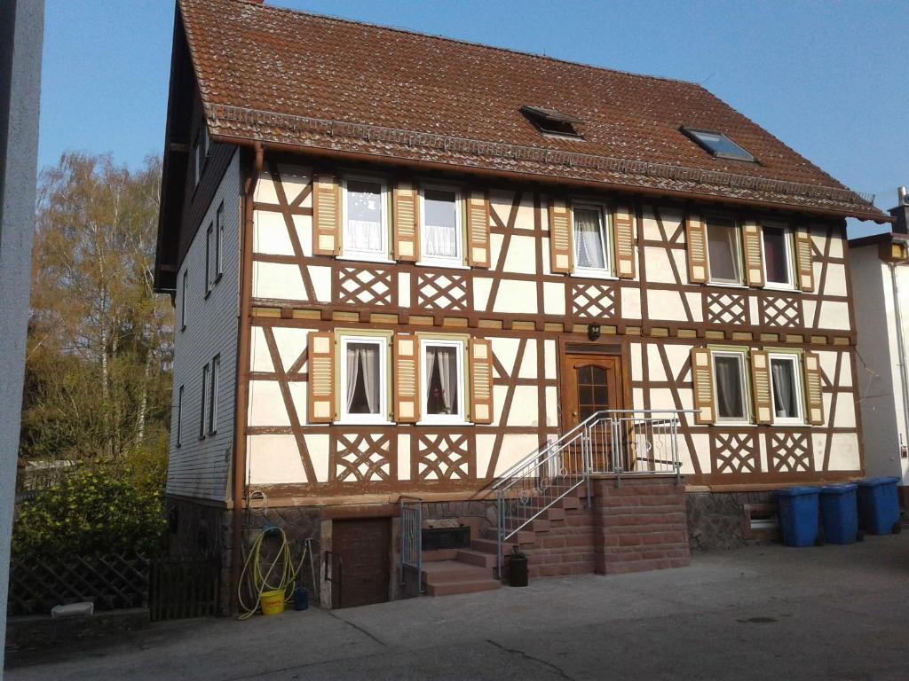 a half timbered house with a staircase in front of it at Kreuzdellenhof _ Ferienwohnung in Hembach