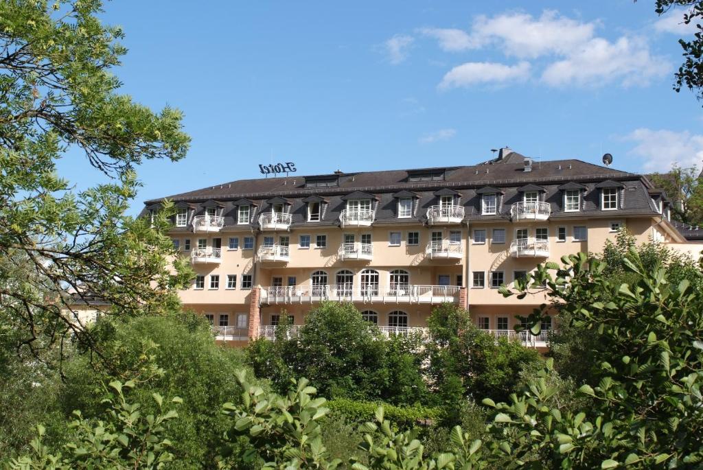 un hotel en medio de algunos árboles en Hotel Lahnschleife en Weilburg