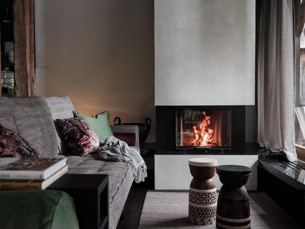 a living room with a couch and a fireplace at Loft im Stadl in Innervillgraten