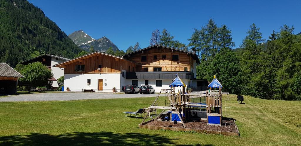 ein Haus mit einem Spielplatz vor einem Feld in der Unterkunft Haus Huber in Bach