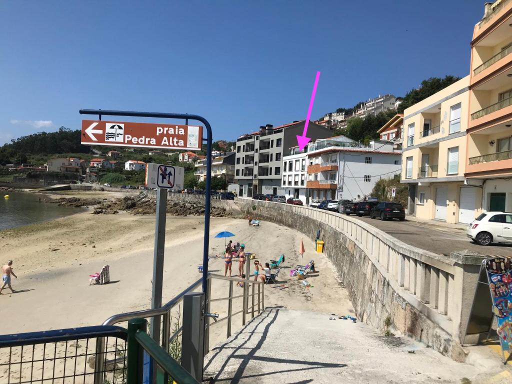 a beach with people on the sand and buildings at Apartamentos Raxo Playa in Raxó