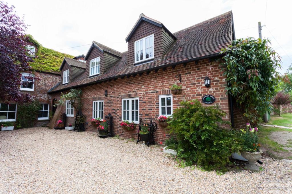 una vieja casa de ladrillo con flores delante en Hanger Down House Bed and Breakfast, en Arundel